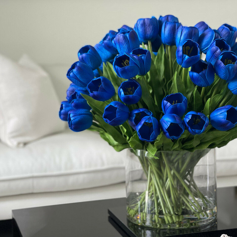 Blaues Tulpenarrangement in großer Zylindervase