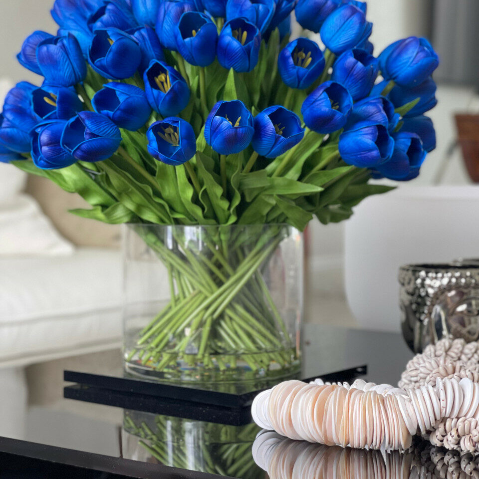 Blaues Tulpenarrangement in großer Zylindervase